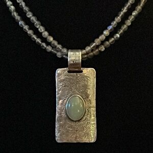 Artisan-crafted vintage silver pendant on string of glass beads